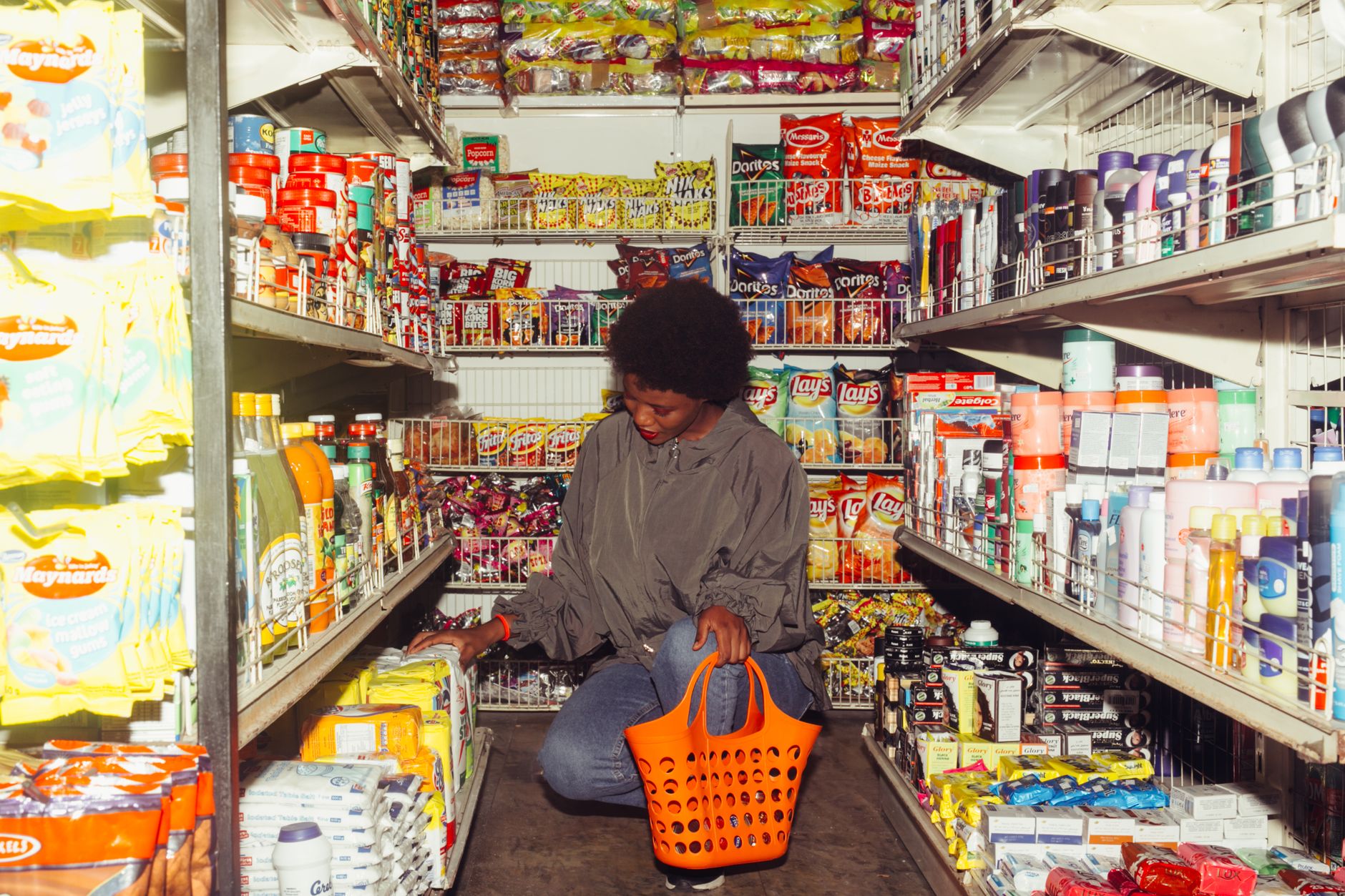 How to save money on groceries for one person while shopping with a basket in a supermarket aisle