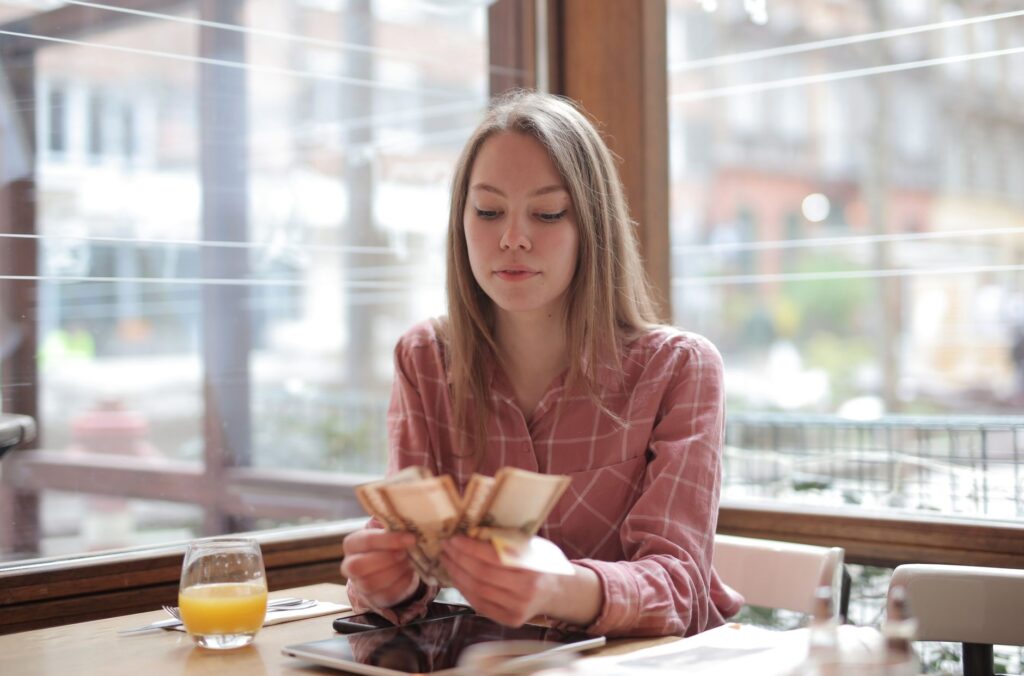 Setting a calm money boundary by texting a friend from a coffee shop